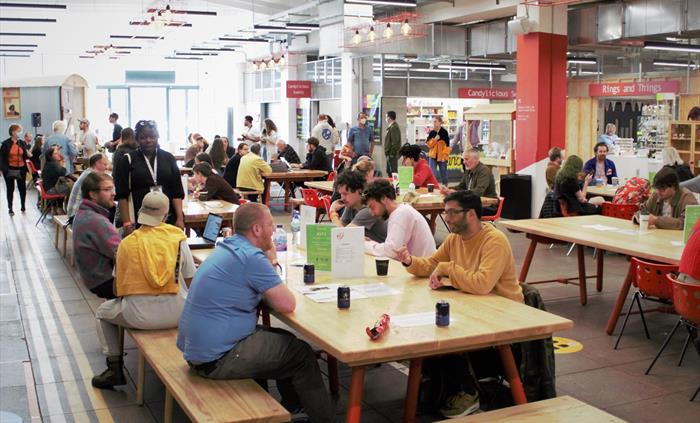 Groups of people sat at various tables in Tŷ Pawb's food court